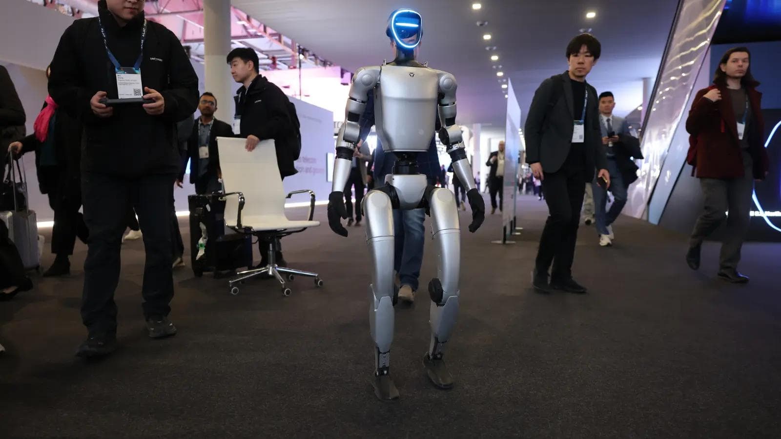Conference exibit space showing a robot walking among people.