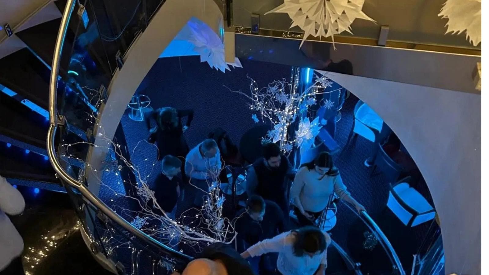 People climbing up a spiral staircase at a Christmas party.
