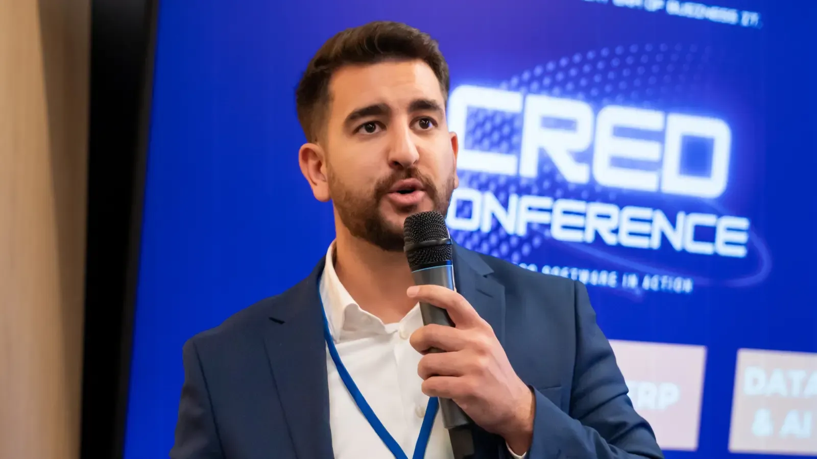 Speaker presenting at CRED Conference 2025.