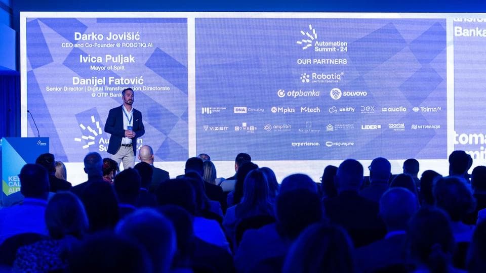 A speaker at a conference stage.
