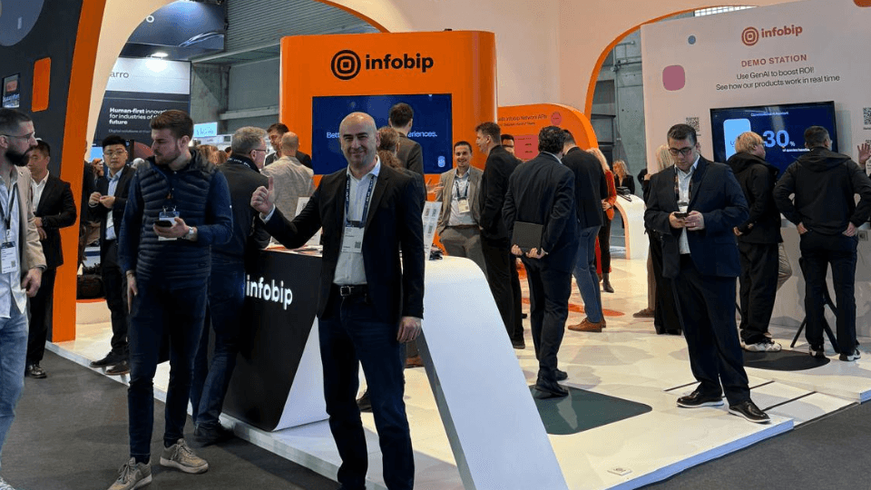 A man standing in front of a Infobip stand at MWC Barcelona booth.