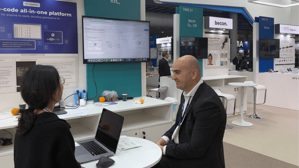 A man and a woman sitting at a conference booth.