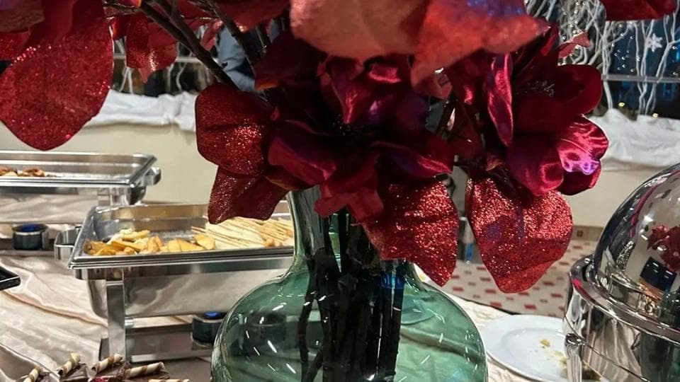 Flower and food at a table at a Christmas business party.