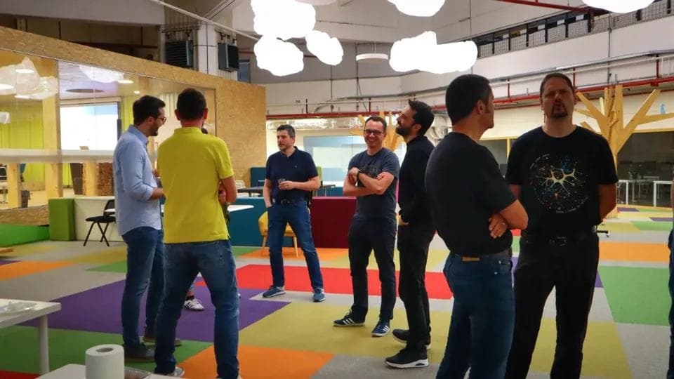 A group of people gathering in circle in an business setting.