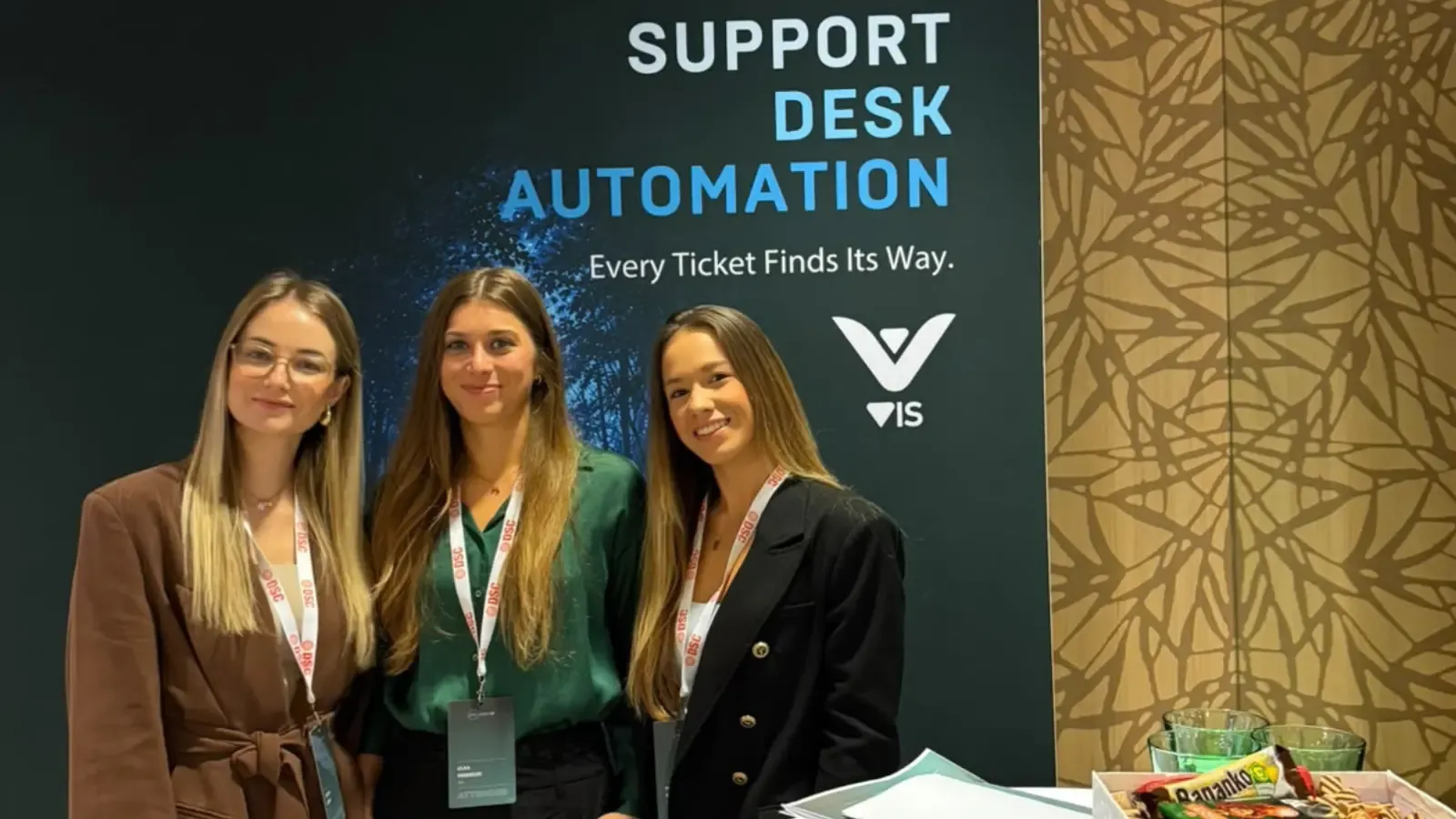 Three VIS Solutions team members at the DSC DACH Support Desk Automation booth in Vienna.