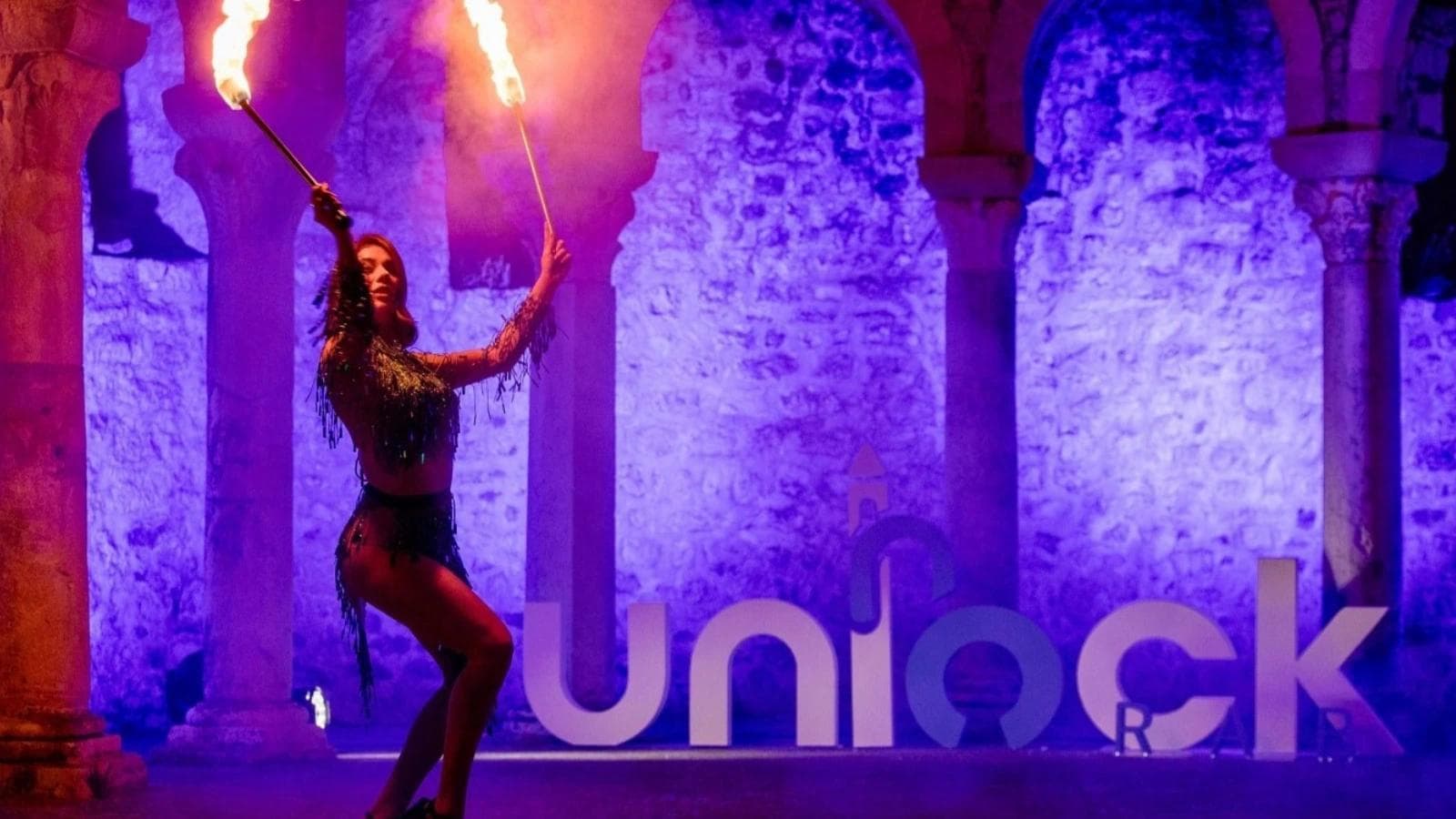 Woman dancing and holding a fire torch at Unlock Rab conference.