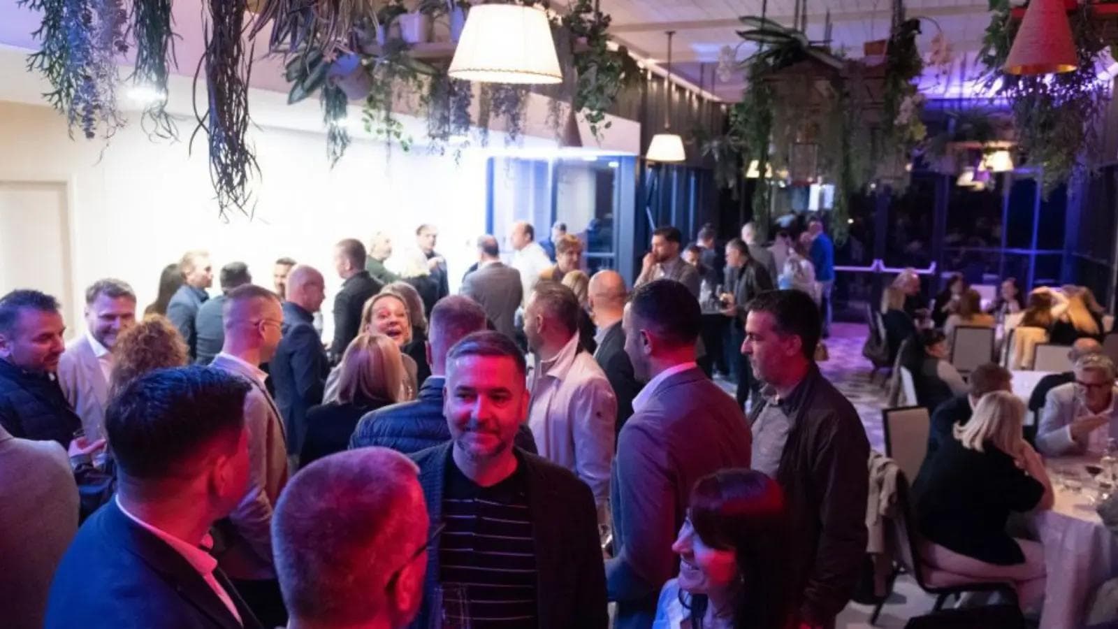People mingling at a conference afterparty.
