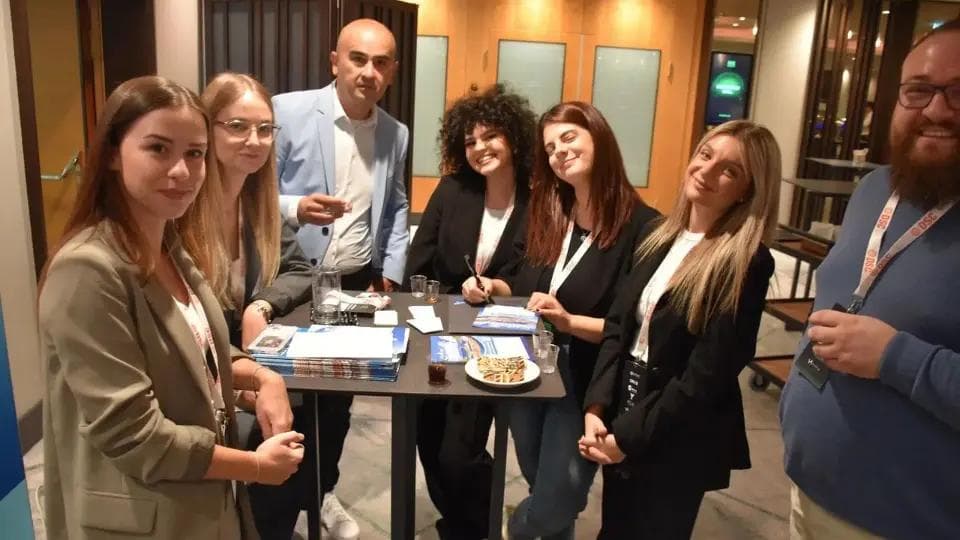 Seven people standing next to each other at a business event.