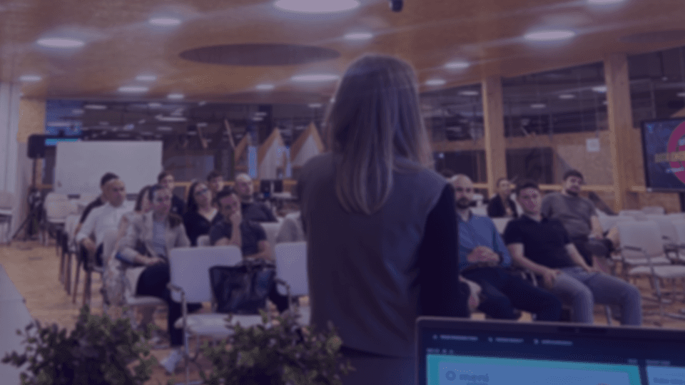 A woman giving a presentation at a conference hall.