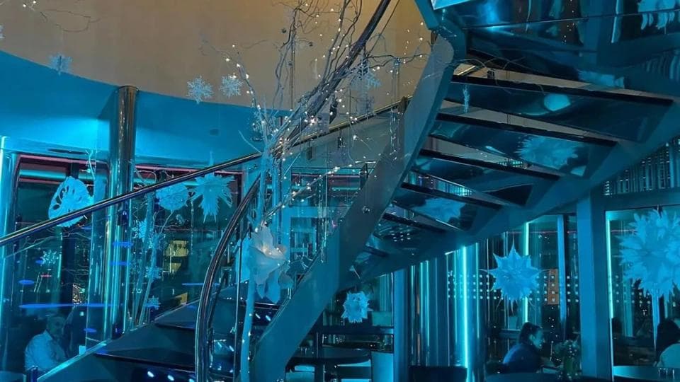 Christmas decor in a modern bar with a central staircase.