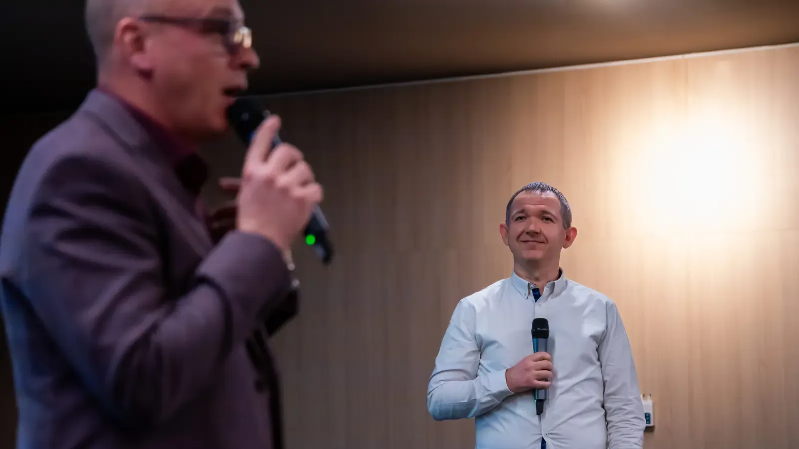 Two speakers with microphones on stage at CRED Conference 2025 in Zagreb.