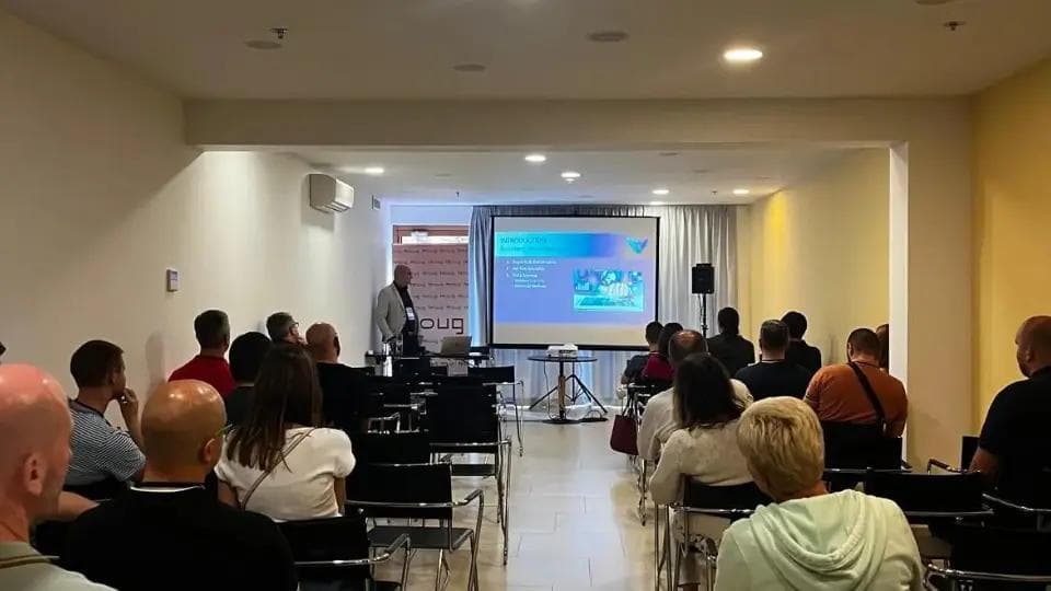 A business man presenting at a seminar in front of an audience.
