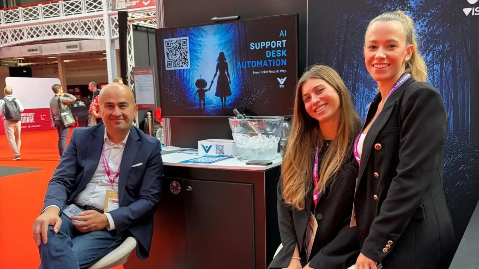 3 people at a Big data London conference stand.